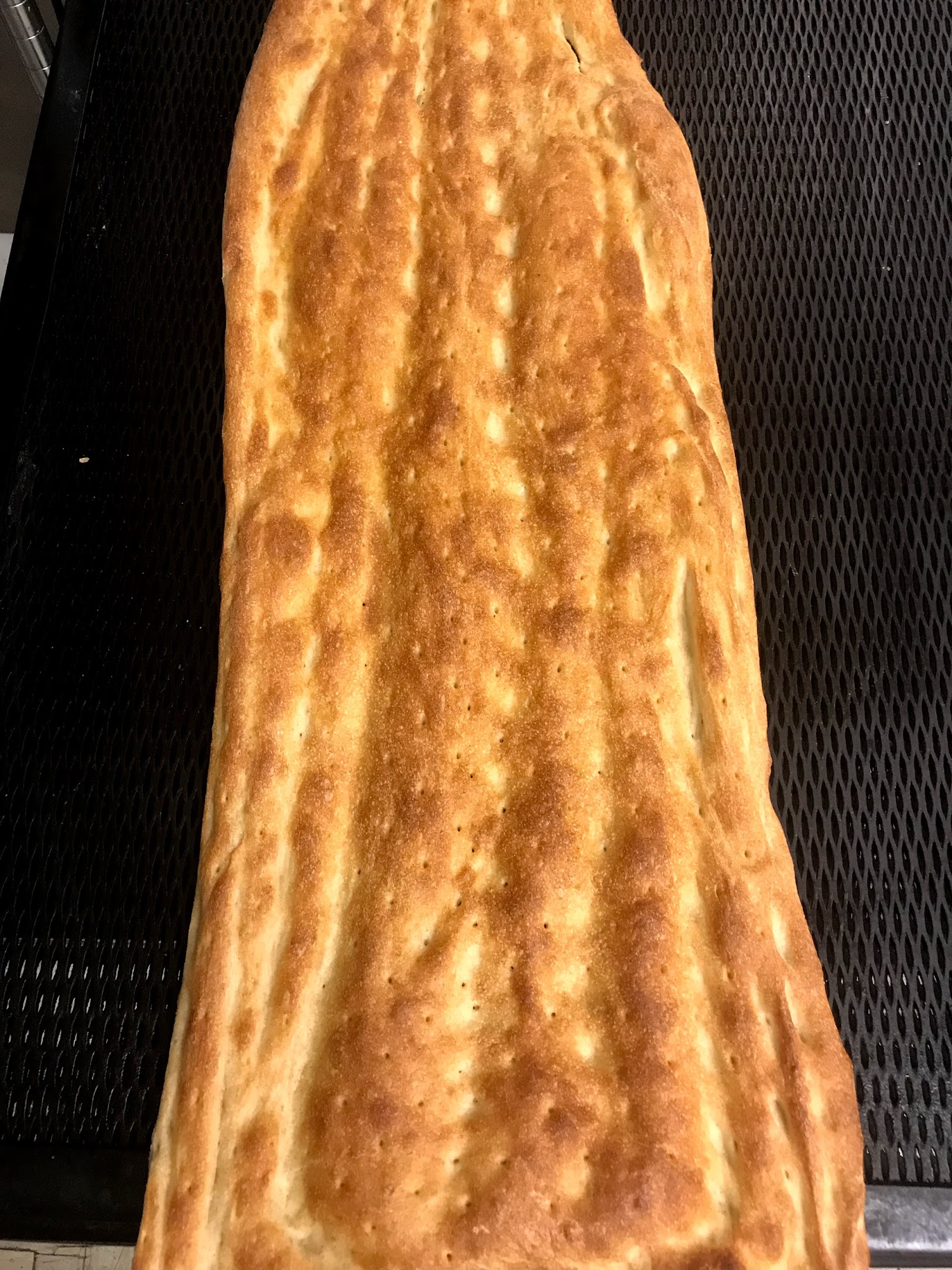 A long golden Afghan naan on the bread rack at Zafron Market