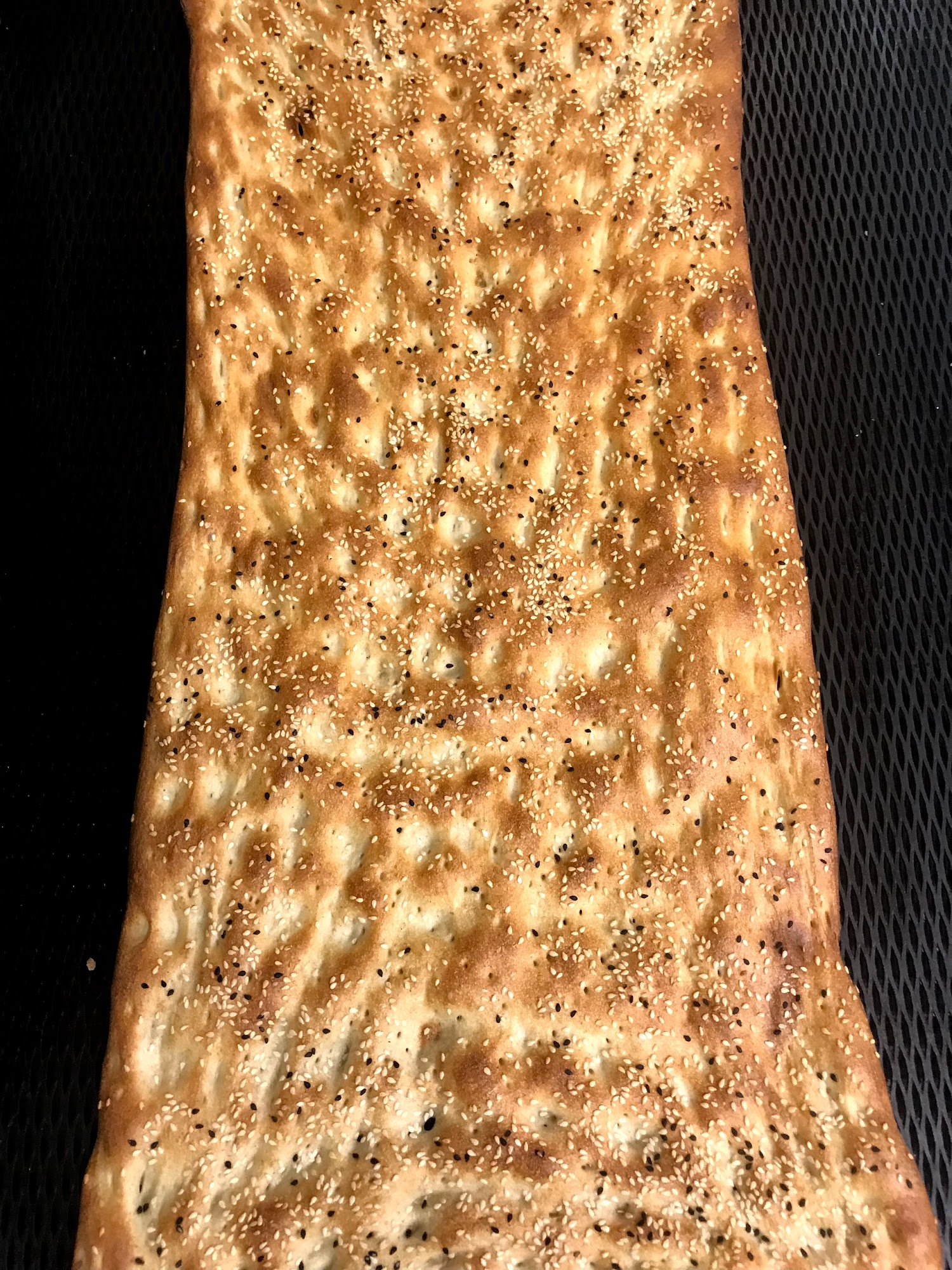Fresh Afghan naan topped with seeds at Zafron Market